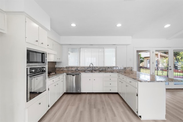 kitchen featuring kitchen peninsula, white cabinetry, light hardwood / wood-style floors, and appliances with stainless steel finishes