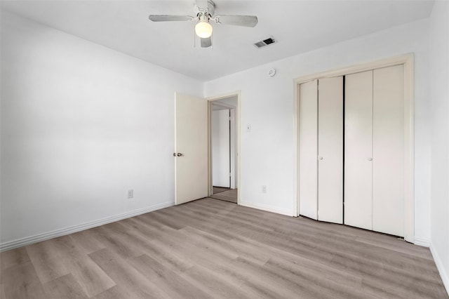 unfurnished bedroom with a closet, light hardwood / wood-style floors, and ceiling fan