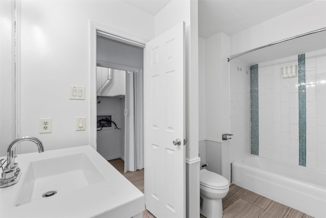 full bathroom featuring toilet, tiled shower / bath, and sink