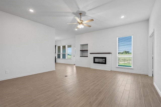 unfurnished living room featuring light hardwood / wood-style flooring, ceiling fan, and a wealth of natural light