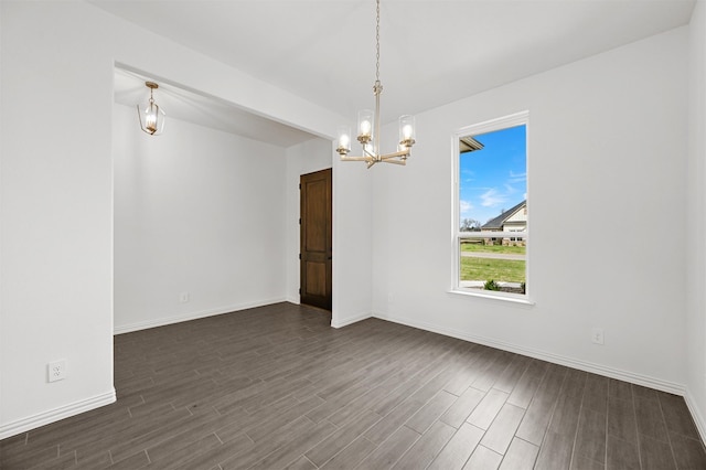 unfurnished room with dark hardwood / wood-style floors and a chandelier