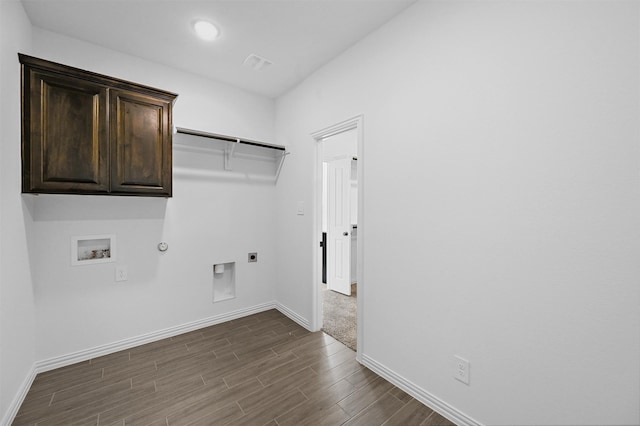 laundry area with cabinets, dark hardwood / wood-style flooring, gas dryer hookup, hookup for a washing machine, and hookup for an electric dryer