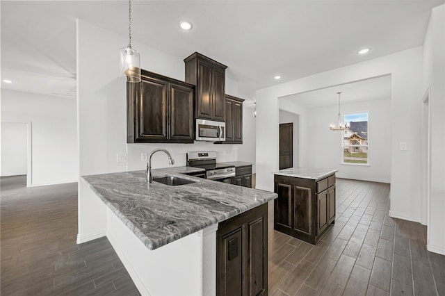 kitchen with sink, appliances with stainless steel finishes, kitchen peninsula, and pendant lighting