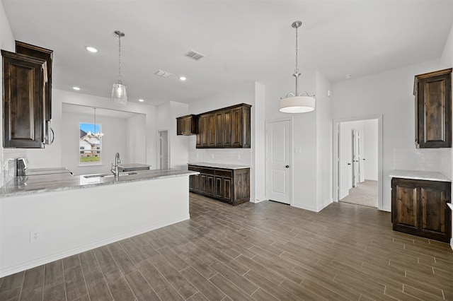 kitchen with range, dark brown cabinetry, sink, and hardwood / wood-style floors