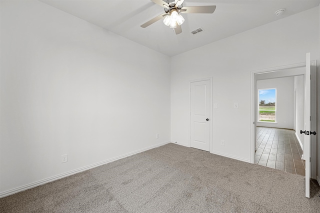 carpeted spare room with ceiling fan