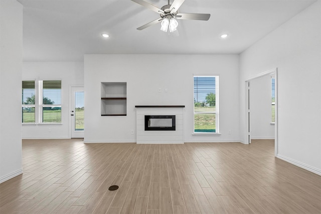 unfurnished living room with ceiling fan and light wood-type flooring