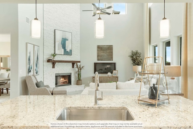 kitchen featuring a high ceiling, sink, plenty of natural light, and decorative light fixtures