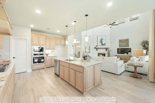 kitchen featuring light brown cabinetry, light hardwood / wood-style floors, appliances with stainless steel finishes, and sink