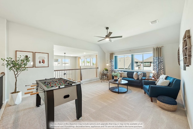 recreation room with vaulted ceiling, ceiling fan, and light colored carpet