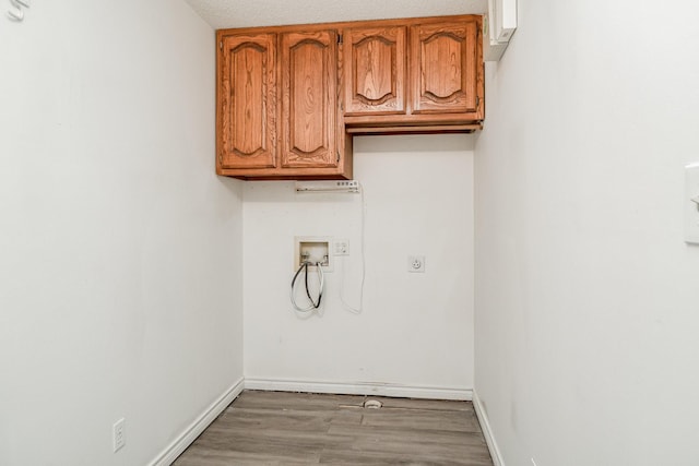 laundry room featuring cabinets, washer hookup, a textured ceiling, and light hardwood / wood-style flooring