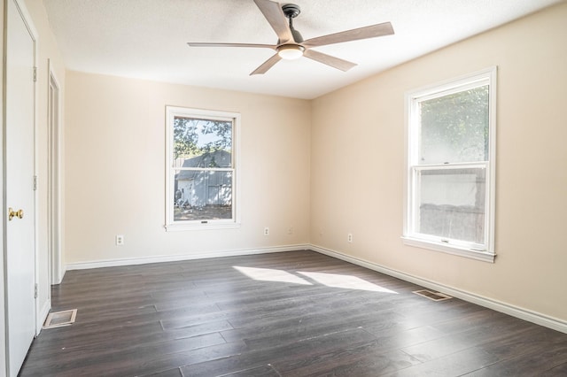 empty room featuring ceiling fan, dark hardwood / wood-style flooring, and a textured ceiling