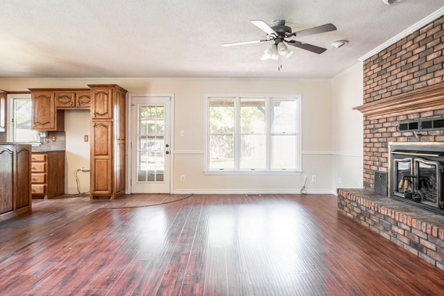 unfurnished living room with ceiling fan, dark wood-type flooring, a textured ceiling, and ornamental molding