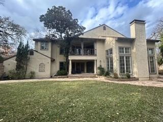 rear view of property with a yard, a balcony, and a patio area