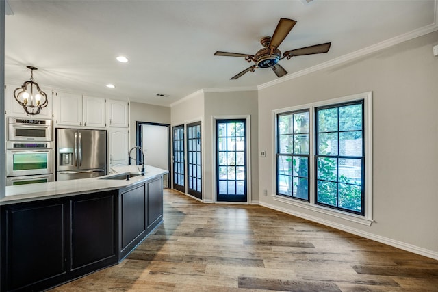 kitchen featuring hanging light fixtures, sink, light wood-type flooring, and appliances with stainless steel finishes