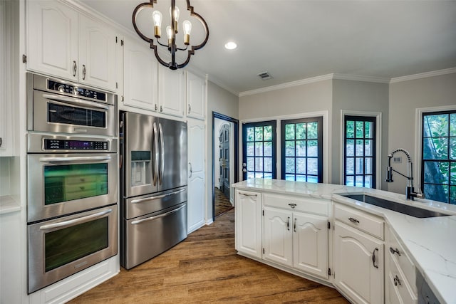 kitchen featuring sink, white cabinets, stainless steel appliances, and light wood-type flooring