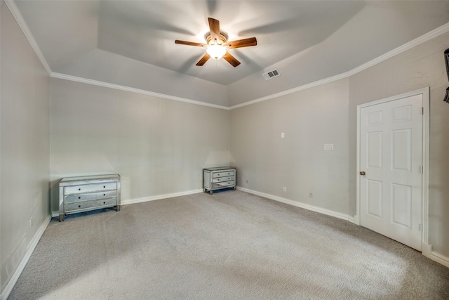 carpeted empty room featuring a tray ceiling, ceiling fan, and crown molding