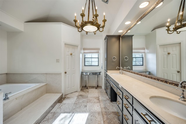 bathroom with plenty of natural light, lofted ceiling, vanity, and tiled bath