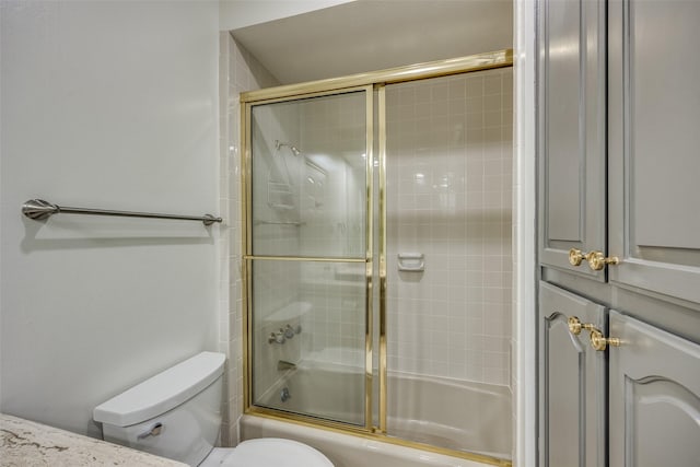 bathroom featuring shower / bath combination with glass door and toilet