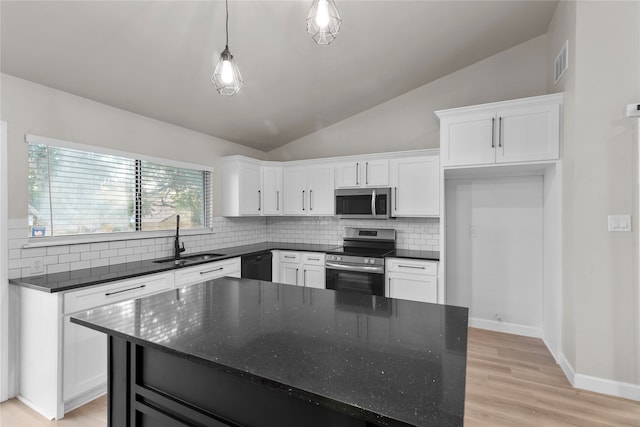 kitchen with white cabinetry, sink, hanging light fixtures, stainless steel appliances, and vaulted ceiling