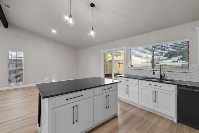 kitchen with white cabinets, black dishwasher, light hardwood / wood-style flooring, and sink