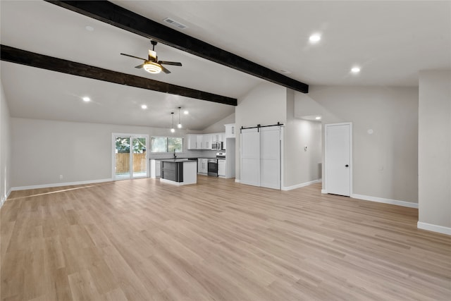 unfurnished living room featuring vaulted ceiling with beams, a barn door, light wood-type flooring, and ceiling fan