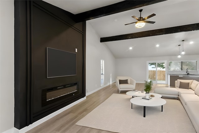 living room featuring vaulted ceiling with beams, ceiling fan, light hardwood / wood-style flooring, and sink