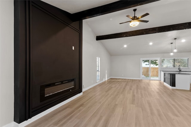 unfurnished living room with vaulted ceiling with beams, ceiling fan, sink, and light hardwood / wood-style flooring