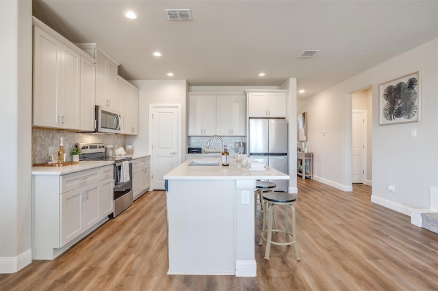 kitchen featuring light hardwood / wood-style flooring, white cabinetry, and appliances with stainless steel finishes