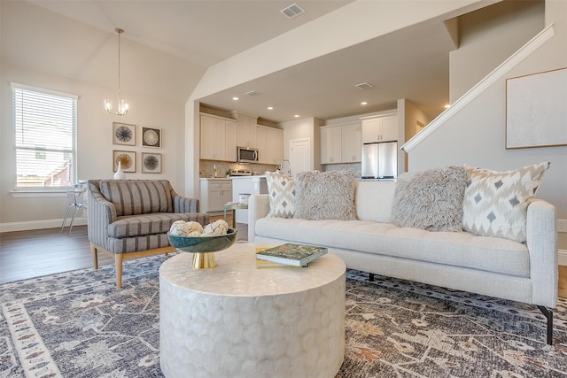 living room with vaulted ceiling, dark hardwood / wood-style flooring, and a notable chandelier