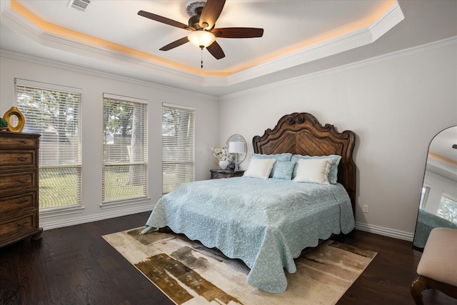 bedroom with a tray ceiling, ceiling fan, dark hardwood / wood-style floors, and ornamental molding