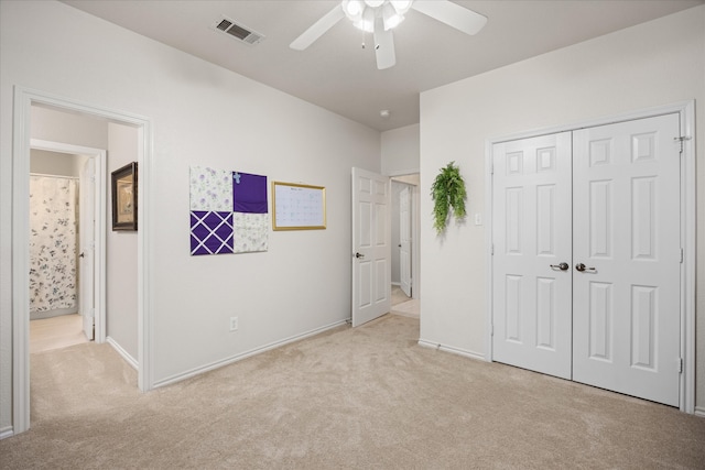 unfurnished bedroom with ceiling fan, a closet, and light carpet