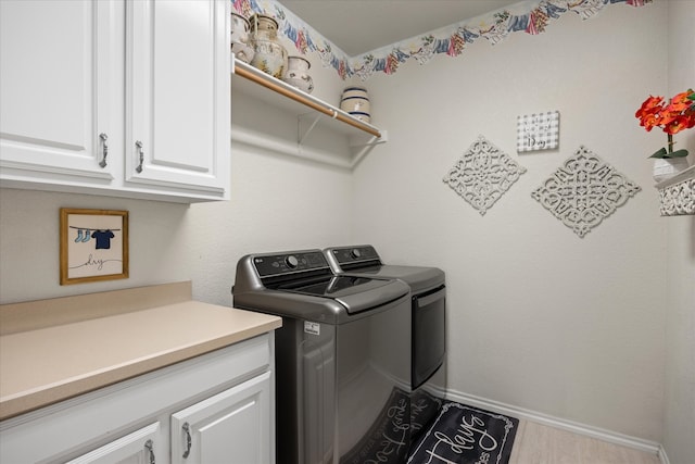 clothes washing area featuring washer and dryer and cabinets