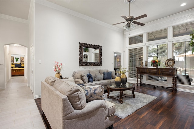 living room featuring a towering ceiling, ceiling fan, and crown molding