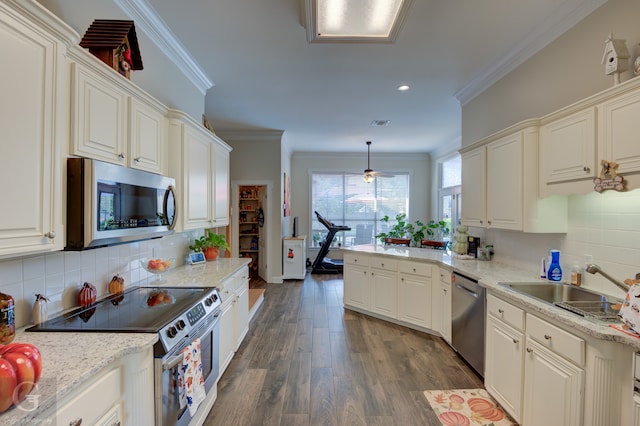 kitchen with tasteful backsplash, dark wood-type flooring, hanging light fixtures, appliances with stainless steel finishes, and crown molding