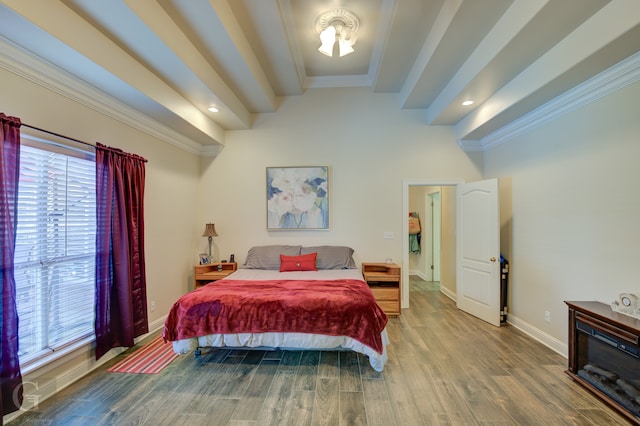 bedroom with beamed ceiling, hardwood / wood-style flooring, and crown molding