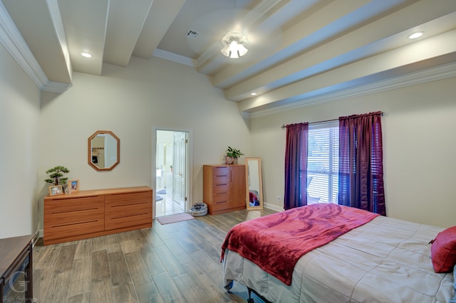 bedroom with crown molding, light hardwood / wood-style floors, and ensuite bath