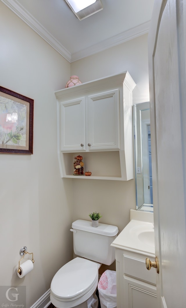 bathroom with ornamental molding, vanity, and toilet