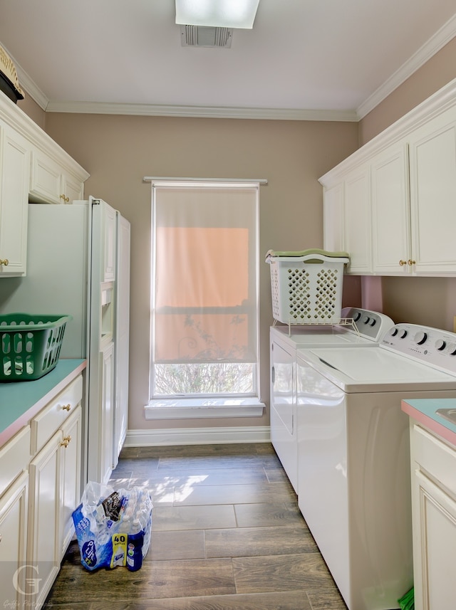 clothes washing area with cabinets, independent washer and dryer, ornamental molding, and dark hardwood / wood-style flooring