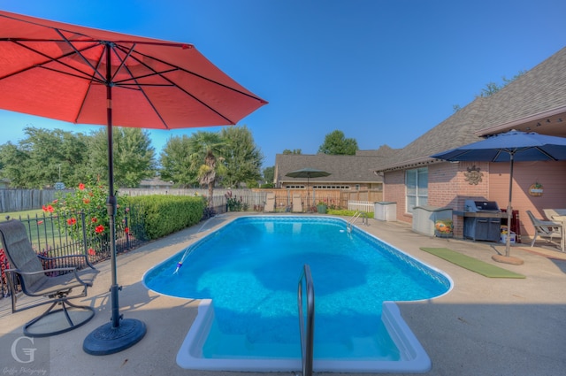 view of pool featuring grilling area and a patio