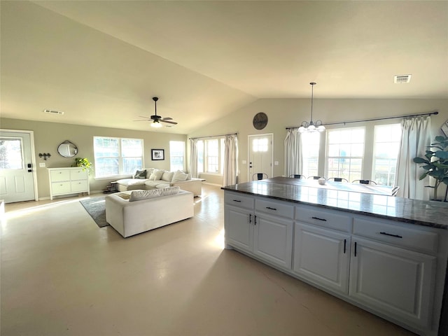 kitchen with white cabinets, ceiling fan with notable chandelier, hanging light fixtures, and vaulted ceiling