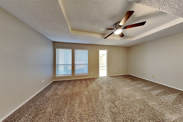 carpeted empty room with a textured ceiling, a raised ceiling, and ceiling fan