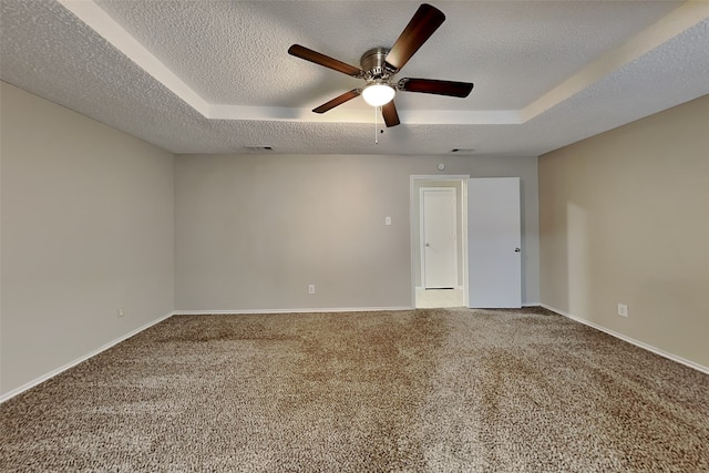 carpeted spare room with a textured ceiling, a raised ceiling, and ceiling fan