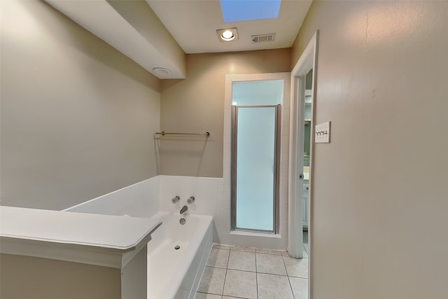 bathroom featuring tile patterned flooring, a skylight, and plus walk in shower