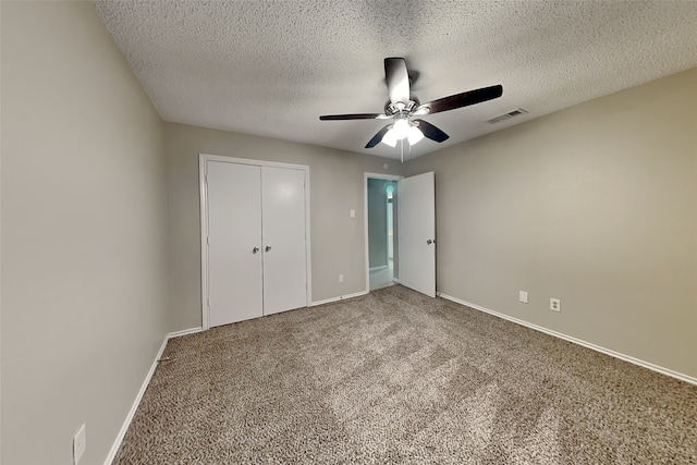 unfurnished bedroom with a textured ceiling, carpet, ceiling fan, and a closet