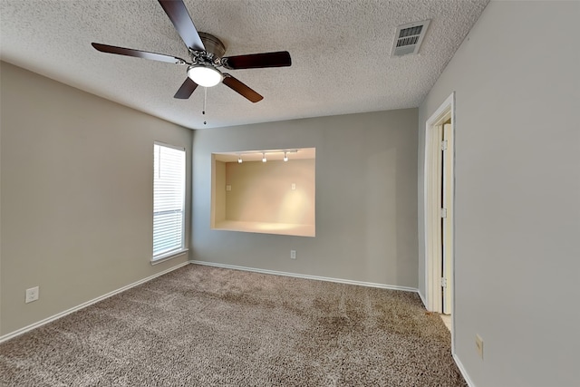 carpeted spare room with a textured ceiling and ceiling fan