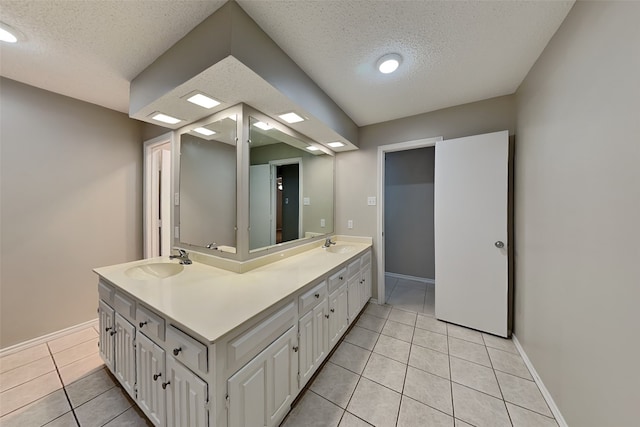 bathroom with vanity, tile patterned flooring, and a textured ceiling