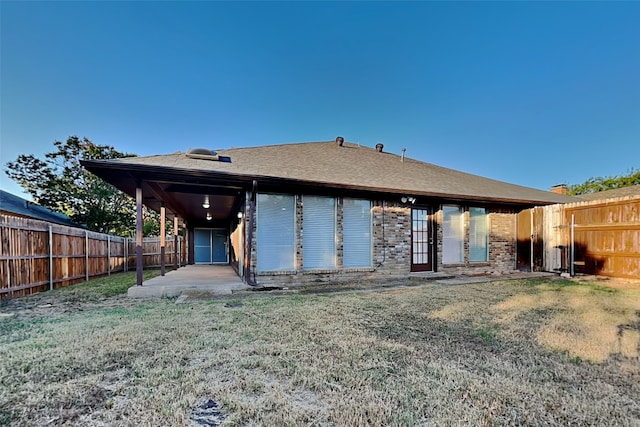 rear view of house with a yard and a patio