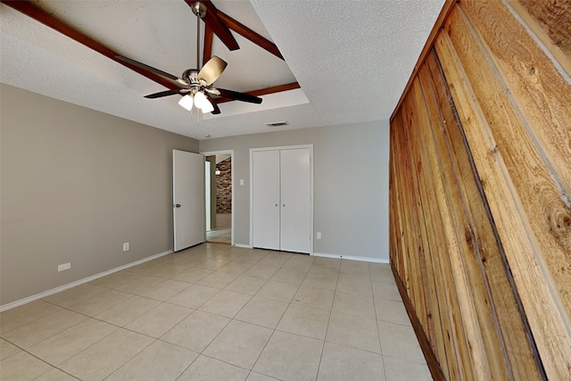 unfurnished bedroom featuring ceiling fan, a textured ceiling, and light tile patterned flooring