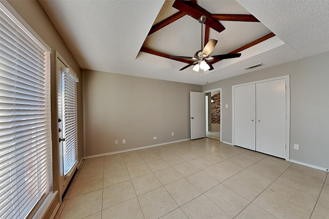 unfurnished bedroom with a textured ceiling, light tile patterned floors, and ceiling fan