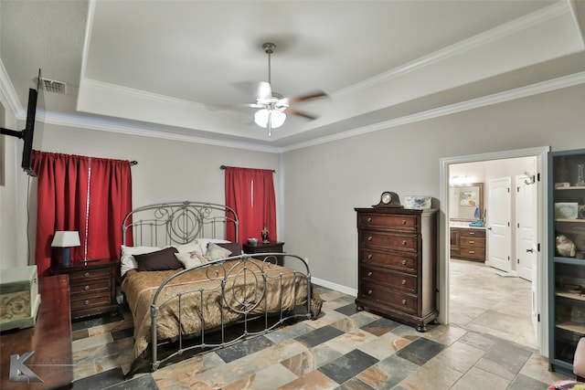 bedroom featuring ceiling fan, connected bathroom, a tray ceiling, and crown molding